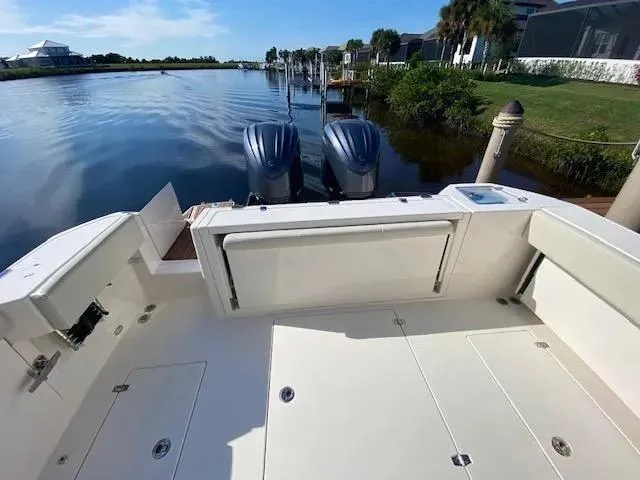 Slide: The Image of 2021 Cobia 330 Dual Console boat docked by a serene waterfront. - 36