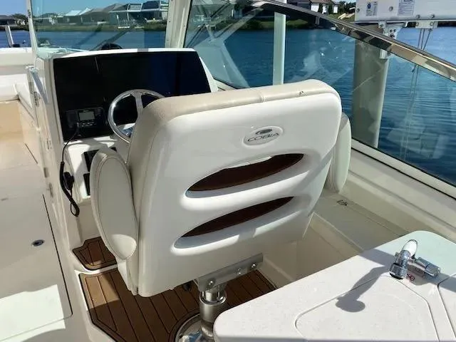 Slide: The Image of 2021 Cobia 330 Dual Console boat interior with captain's chair and control panel. - 38