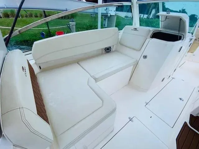 Slide: The Image of 2021 Cobia 330 Dual Console boat interior with white cushioned seating. - 4