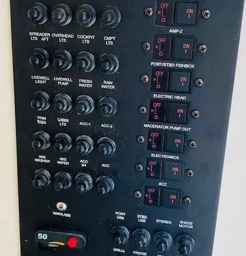 Slide: The Image of Control panel of a 2021 Cobia 330 Dual Console boat with various switches and buttons. - 5