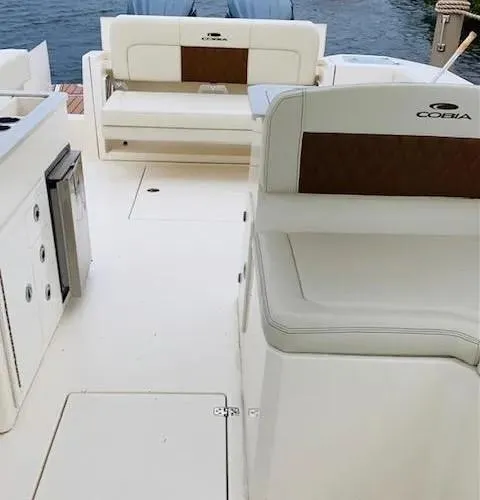 Slide: The Image of 2021 Cobia 330 Dual Console boat interior with white seating and brown accents. - 6