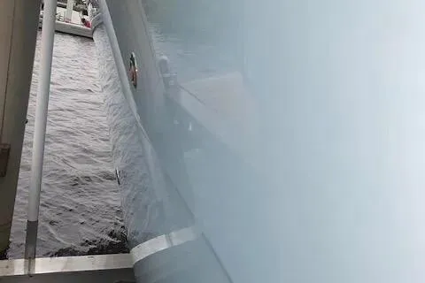 Slide: The Image of 2021 Cobia 330 Dual Console boat on water, side view. - 9