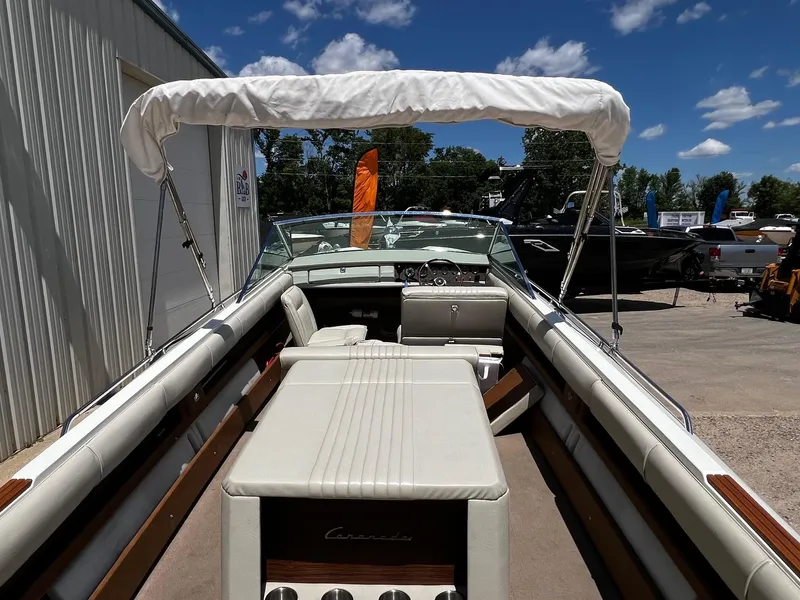 Slide: The Image of 1973 Century Coronado boat with white interior and canopy, parked outdoors under a blue sky. - 14