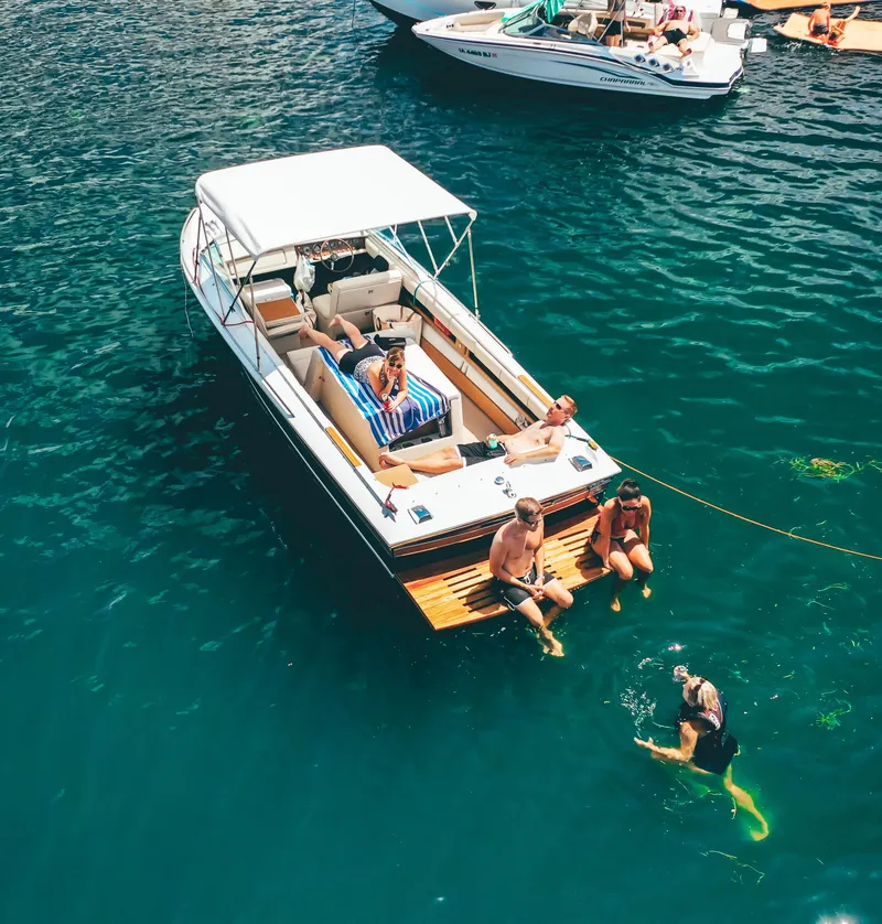 Slide: The Image of People relaxing on a 1973 Century Coronado boat in clear blue water. - 7