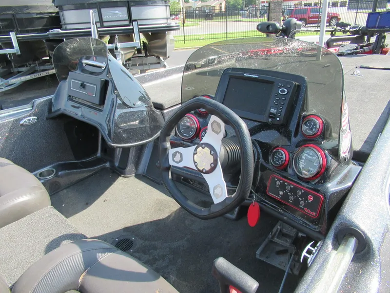Slide: The Image of 2014 Bass Cat Cougar FTD boat dashboard with steering wheel and electronic controls. - 2