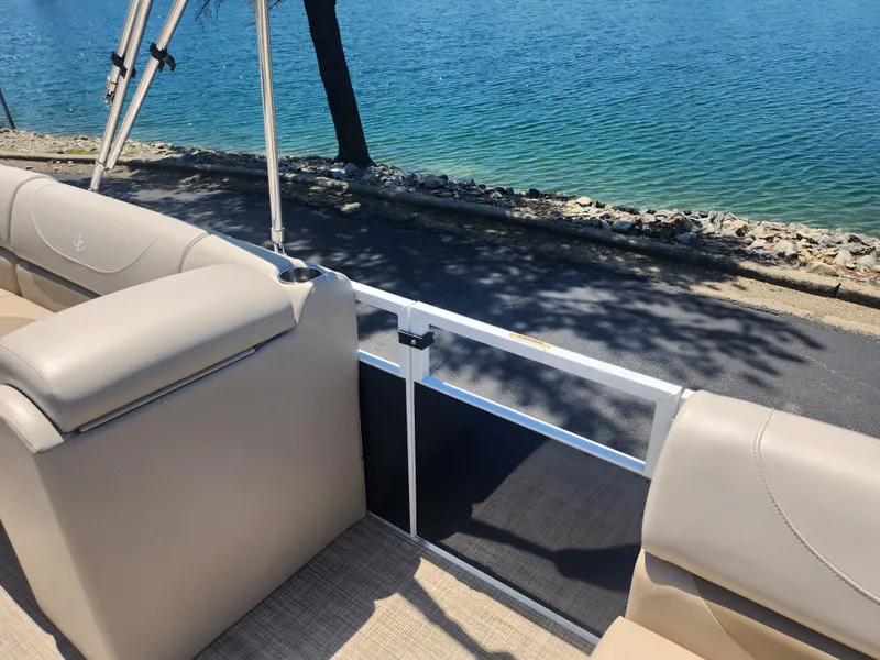 Slide: The Image of Interior of a 2019 JC 222 Spirit boat with beige seating by the water. - 11