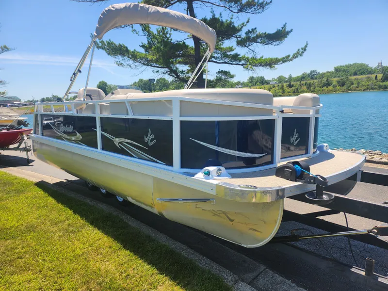 Slide: The Image of 2019 JC 222 Spirit pontoon boat docked by a lake on a sunny day. - 7