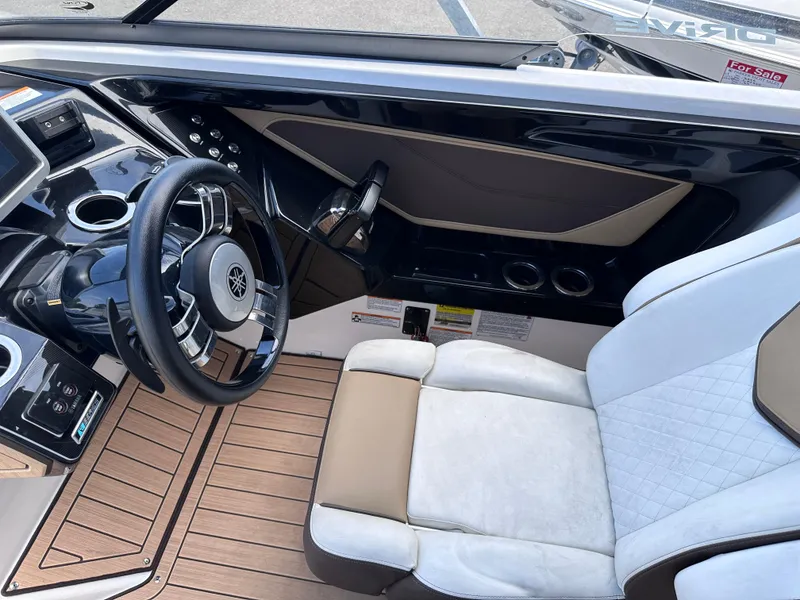 Slide: The Image of 2021 Yamaha Boats 252 SD cockpit with steering wheel and comfortable seating. - 13