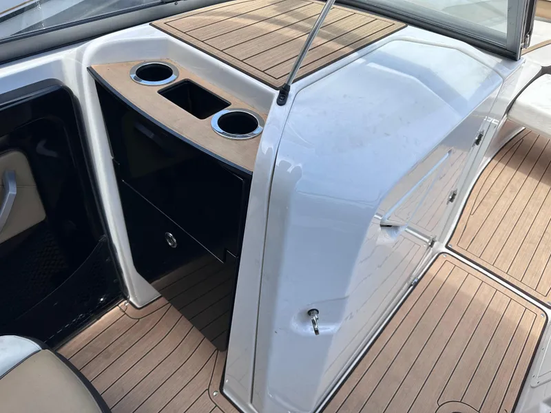 Slide: The Image of Interior of 2021 Yamaha Boats 252 SD, featuring cup holders and wood finish. - 18