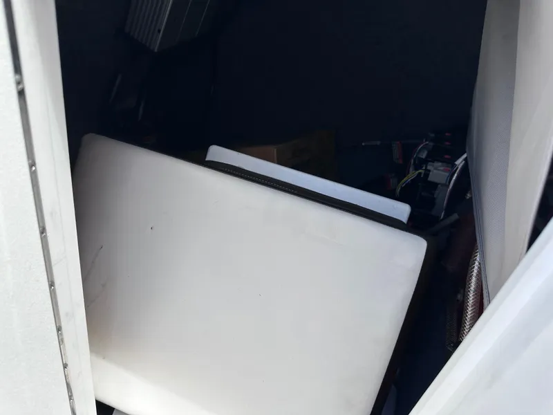 Slide: The Image of Storage compartment of a 2021 Yamaha Boats 252 SD with equipment and wiring. - 35