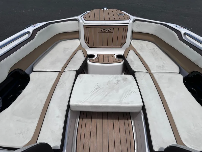 Slide: The Image of 2021 Yamaha Boats 252 SD interior seating with cushioned seats and wood accents. - 36