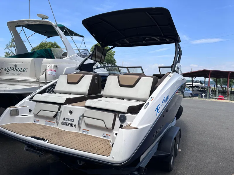 Slide: The Image of 2021 Yamaha Boats 252 SD on trailer, docked near other boats. - 4