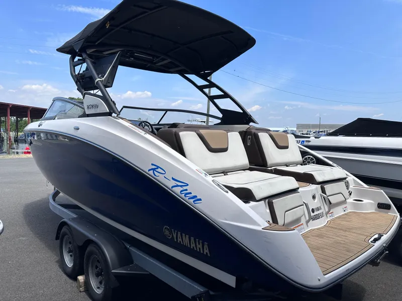 Slide: The Image of 2021 Yamaha Boats 252 SD, blue and white, on a trailer, rear view. - 6