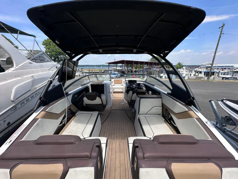 Slide: The Image of 2021 Yamaha Boats 252 SD interior view with seating and dashboard at marina. - 7