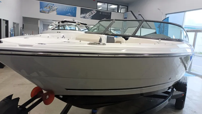 Slide: The Image of 2025 Monterey 224FS boat in showroom, sleek design, white exterior, modern features. - 1