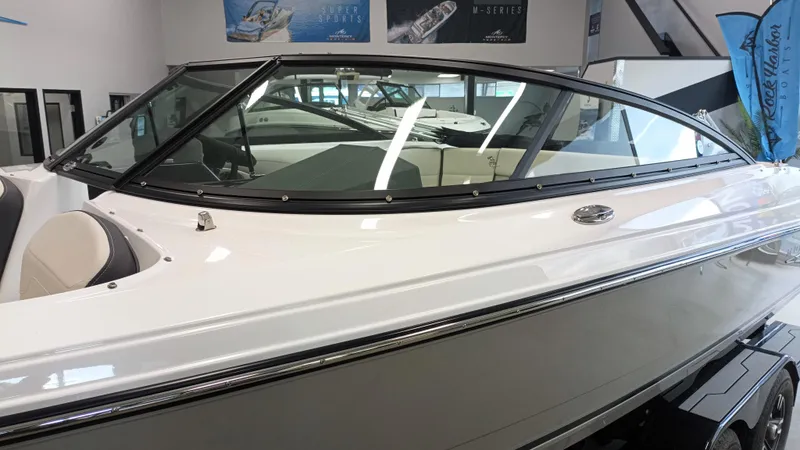 Slide: The Image of 2025 Monterey 224FS boat in showroom, sleek design with black trim and modern features. - 2