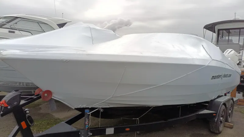 Slide: The Image of 2025 Monterey 224FS boat covered on trailer, ready for transport. - 24