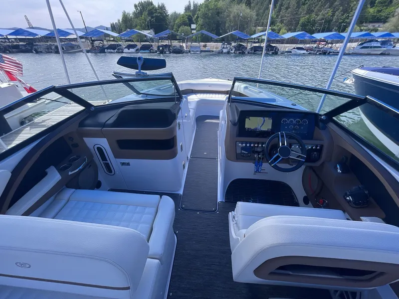 Slide: The Image of 2021 Cobalt R30 boat interior with modern dashboard and seating, docked at a marina. - 10