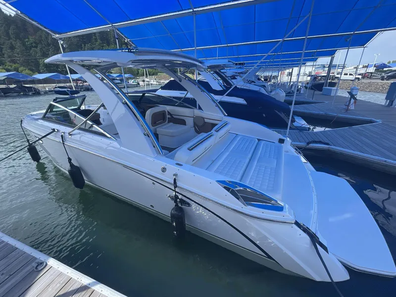Slide: The Image of 2021 Cobalt R30 boat docked under blue canopy at marina. - 3