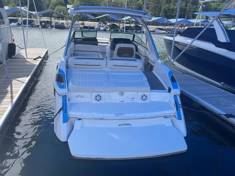 Slide: The Image of 2021 Cobalt R30 boat docked at marina, featuring spacious seating and swim platform. - 4