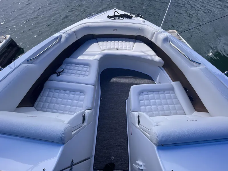 Slide: The Image of 2021 Cobalt R30 boat interior with white cushioned seating on the water. - 8