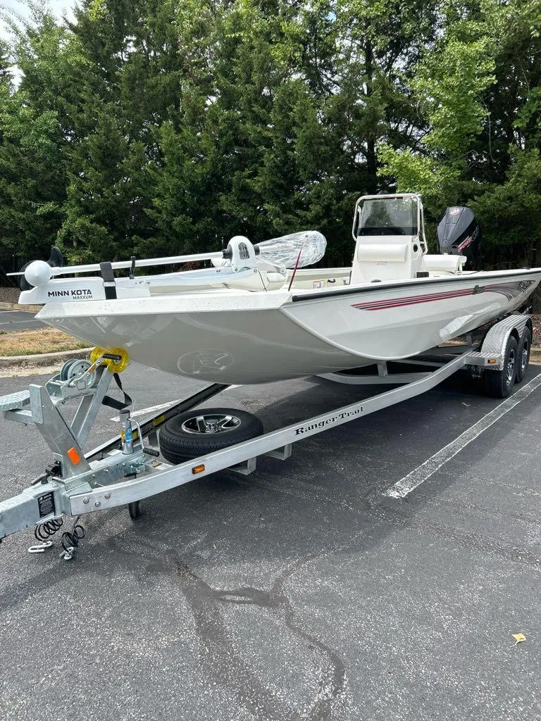 Slide: The Image of 2024 Ranger RB210 boat on trailer, parked outdoors. - 2
