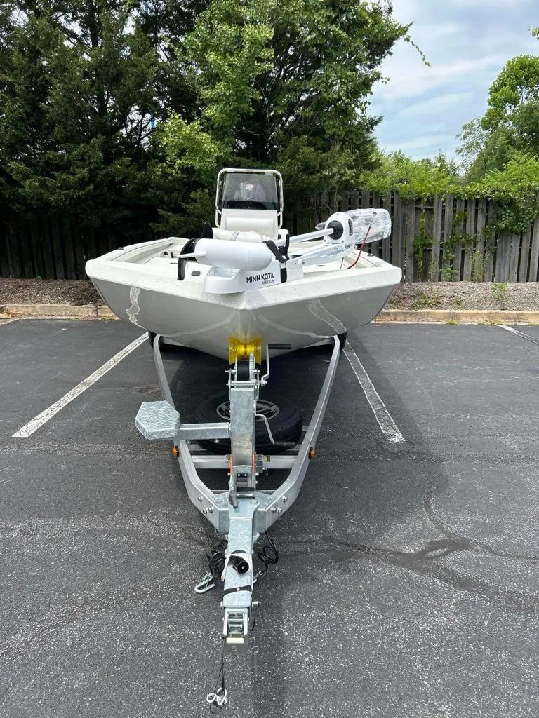 Slide: The Image of 2024 Ranger RB210 boat on trailer in parking lot, surrounded by trees. - 5