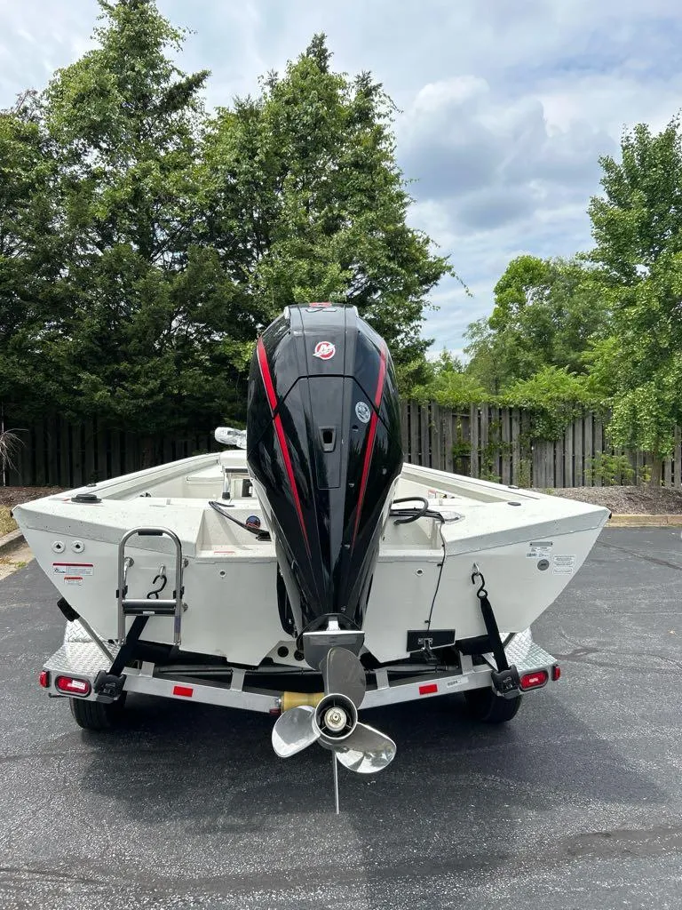Slide: The Image of 2024 Ranger RB210 boat with outboard motor on trailer, parked outdoors. - 7