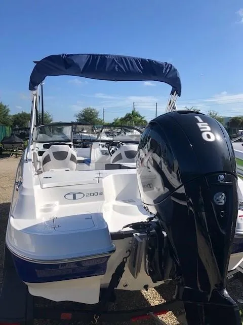 Slide: The Image of 2024 Tahoe 200 S boat with 150 HP engine, blue canopy, and white seating. - 3