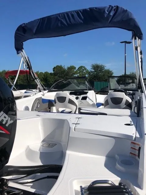 Slide: The Image of 2024 Tahoe 200 S boat with blue canopy and sleek interior design. - 4