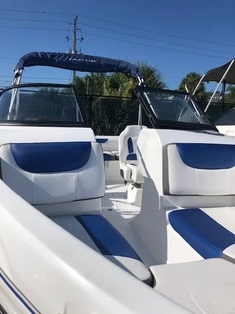 Slide: The Image of 2024 Tahoe 200 S boat interior with blue and white seating under clear sky. - 5