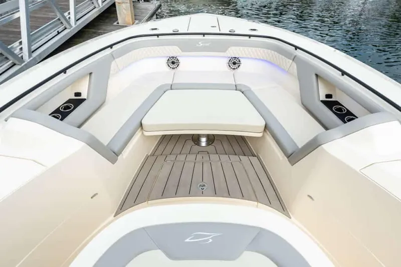 Slide: The Image of 2025 Scout 377 LXF boat interior with cushioned seating and wooden deck. - 12