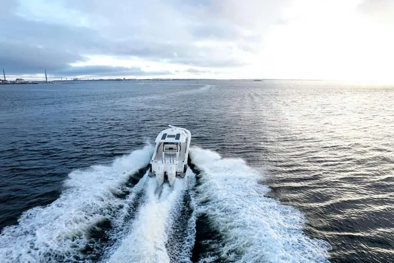 Slide: The Image of 2025 Scout 377 LXF boat cruising on open water at sunset. - 16
