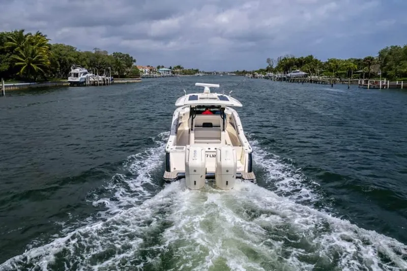 Slide: The Image of 2025 Scout 377 LXF boat cruising on a scenic waterway. - 17