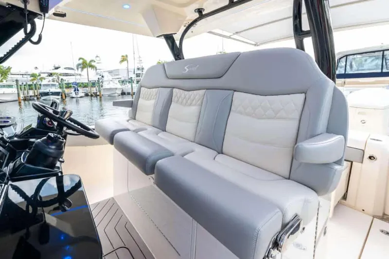 Slide: The Image of 2025 Scout 377 LXF boat interior with luxurious seating at marina. - 4