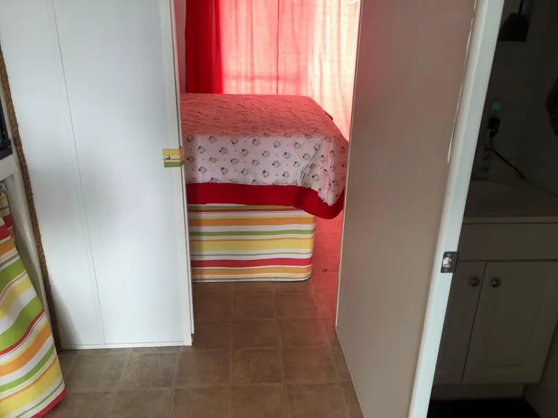 Slide: The Image of Interior of 2013 Catamaran Cruisers 39, featuring a cozy bedroom with colorful decor. - 12