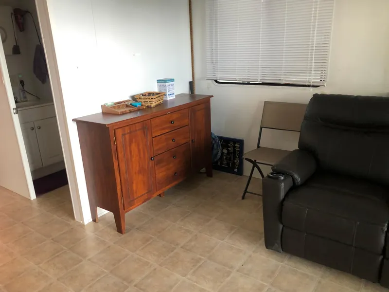 Slide: The Image of Interior of a 2013 Catamaran Cruisers 39 with wooden cabinet and black recliner. - 18