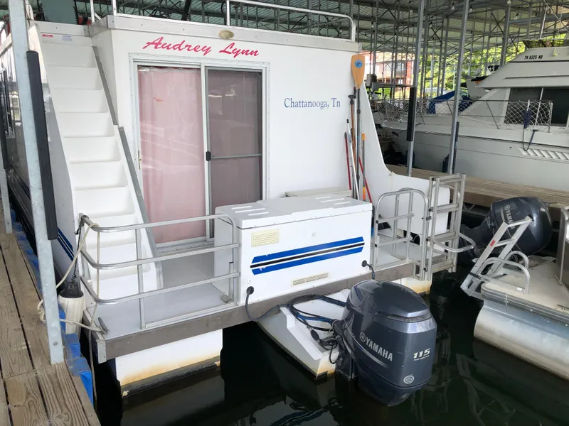 Slide: The Image of 2013 Catamaran Cruisers 39 houseboat docked with Yamaha 115 outboard motor. - 2