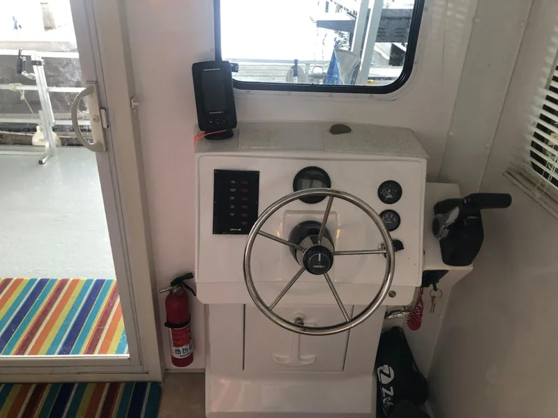 Slide: The Image of Helm station of 2013 Catamaran Cruisers 39 with steering wheel and control panel. - 23