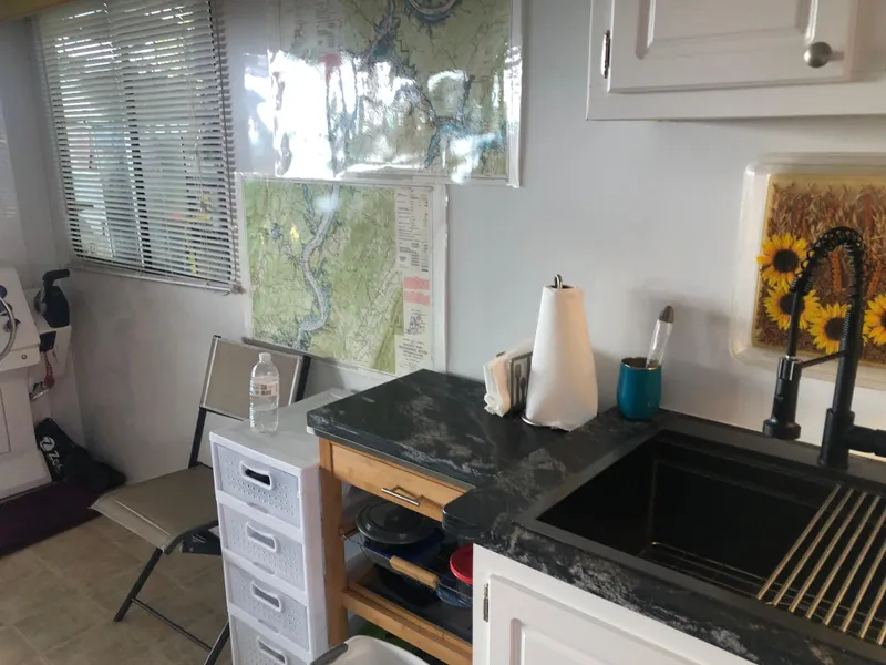 Slide: The Image of Interior of 2013 Catamaran Cruisers 39 with kitchen sink, maps, and storage drawers. - 24