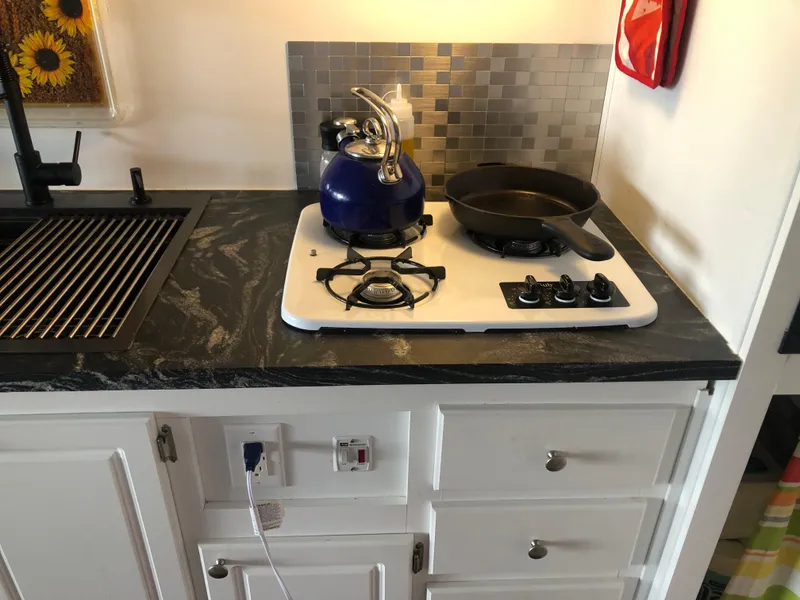 Slide: The Image of Compact kitchen in 2013 Catamaran Cruisers 39 with stove, sink, and modern backsplash. - 28