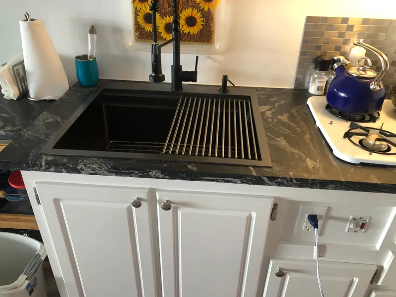 Slide: The Image of Modern kitchen sink in 2013 Catamaran Cruisers 39 with black faucet and marble countertop. - 29