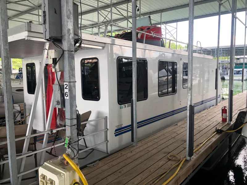 Slide: The Image of 2013 Catamaran Cruisers 39 houseboat docked in a covered marina. - 30