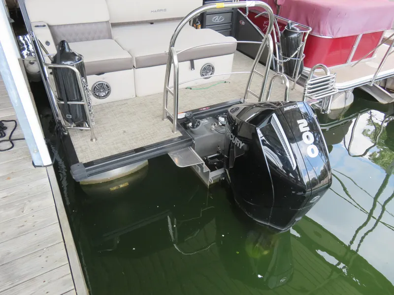 Slide: The Image of 2023 Harris Sunliner 230 pontoon boat with Mercury 200 outboard motor at dock. - 8