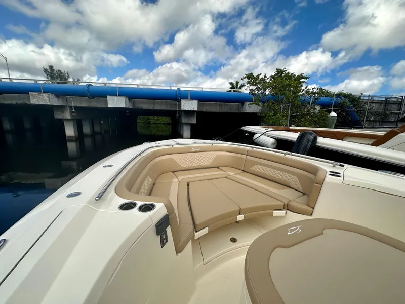 Slide: The Image of 2025 Scout 330 LXF boat with luxurious seating under a blue sky. - 3