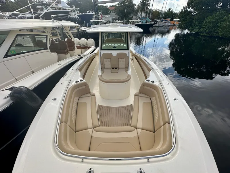 Slide: The Image of 2025 Scout 330 LXF boat with luxurious seating docked in a marina. - 4