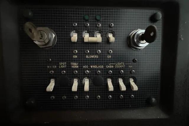 Slide: The Image of Control panel of a 1986 Sea Ray 340 Express Cruiser boat with switches and keys. - 10