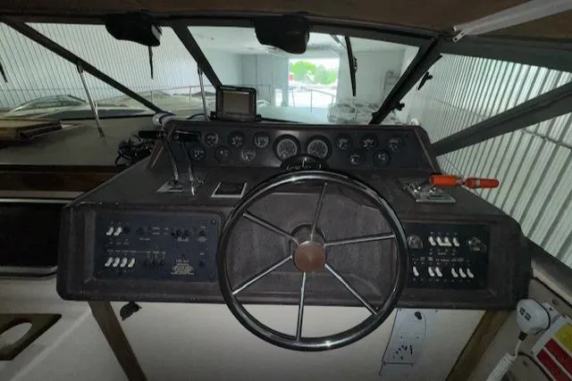 Slide: The Image of 1986 Sea Ray 340 Express Cruiser helm with steering wheel and control panel. - 12