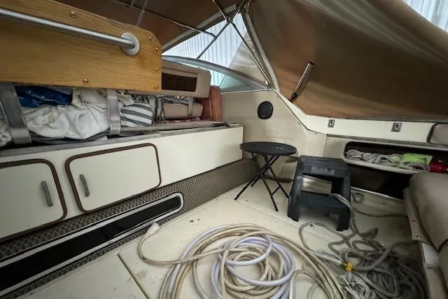 Slide: The Image of 1986 Sea Ray 340 Express Cruiser interior with storage, seating, and coiled ropes. - 15