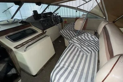 Slide: The Image of Interior of 1986 Sea Ray 340 Express Cruiser with striped bedding and helm station. - 17